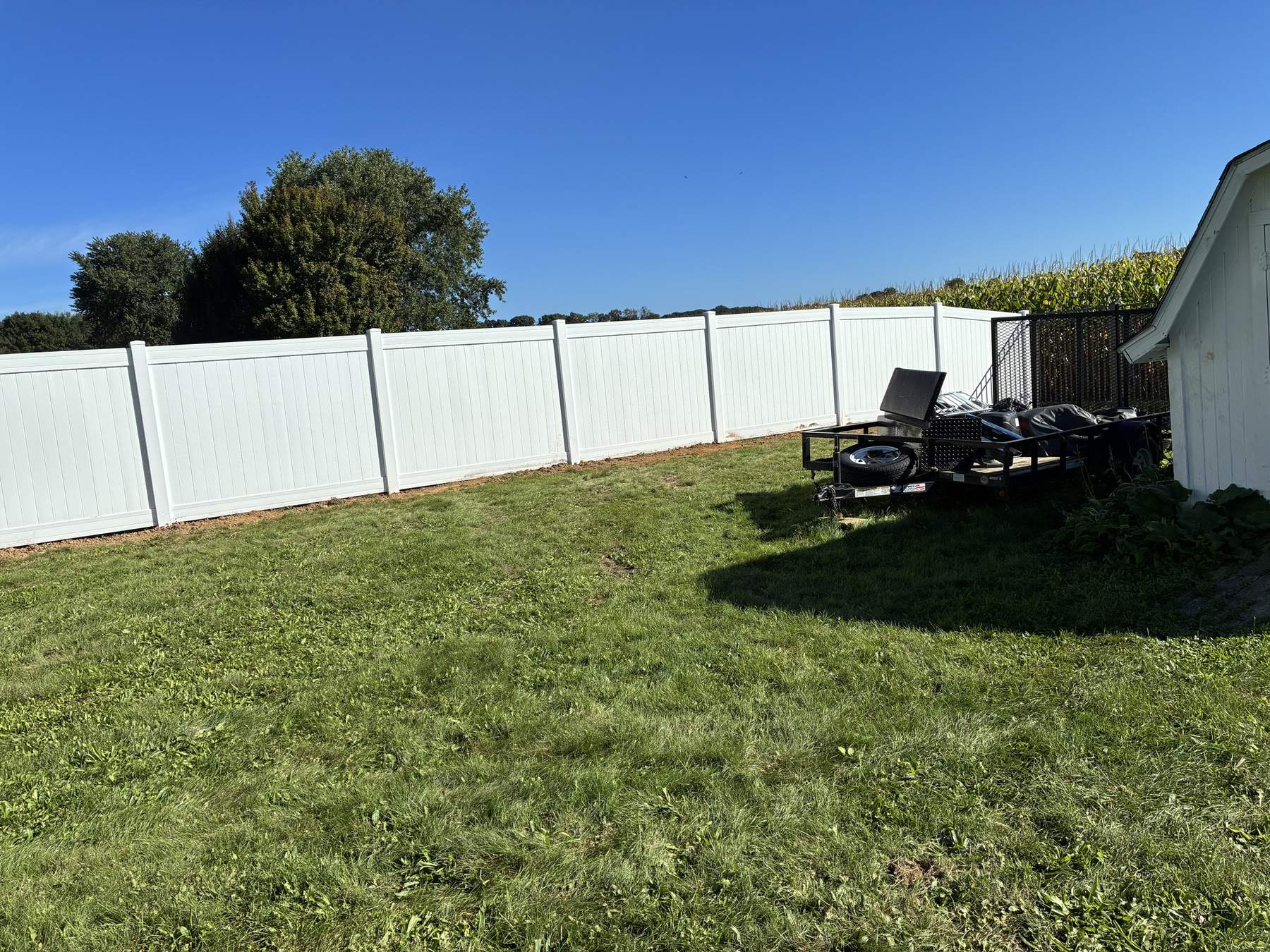White vinyl privacy fence enclosing a backyard lawn in Tuscarawas County, Ohio