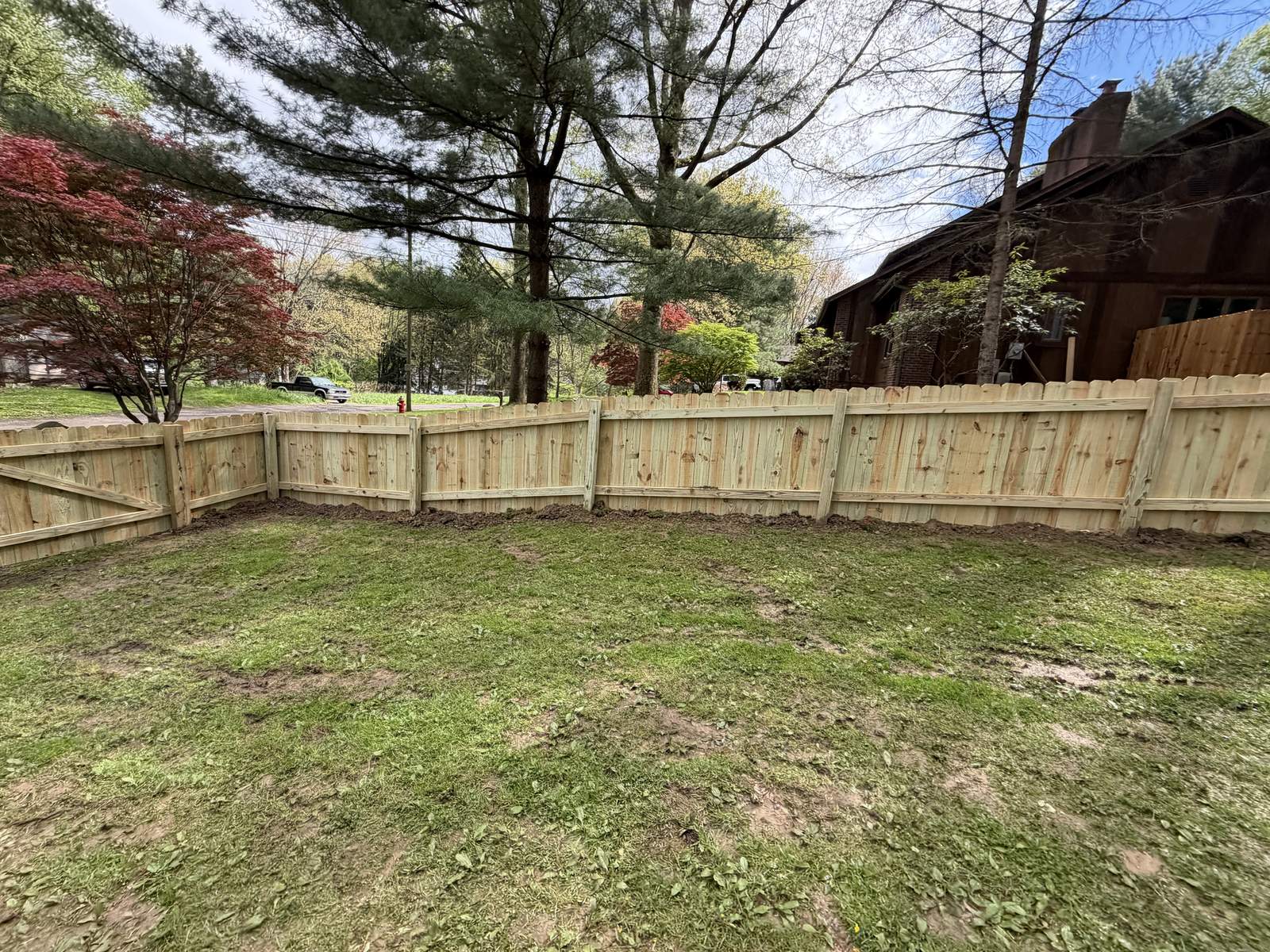 Wood privacy fence enclosing a tree-lined backyard, installed by Warrior Barriers in Ohio