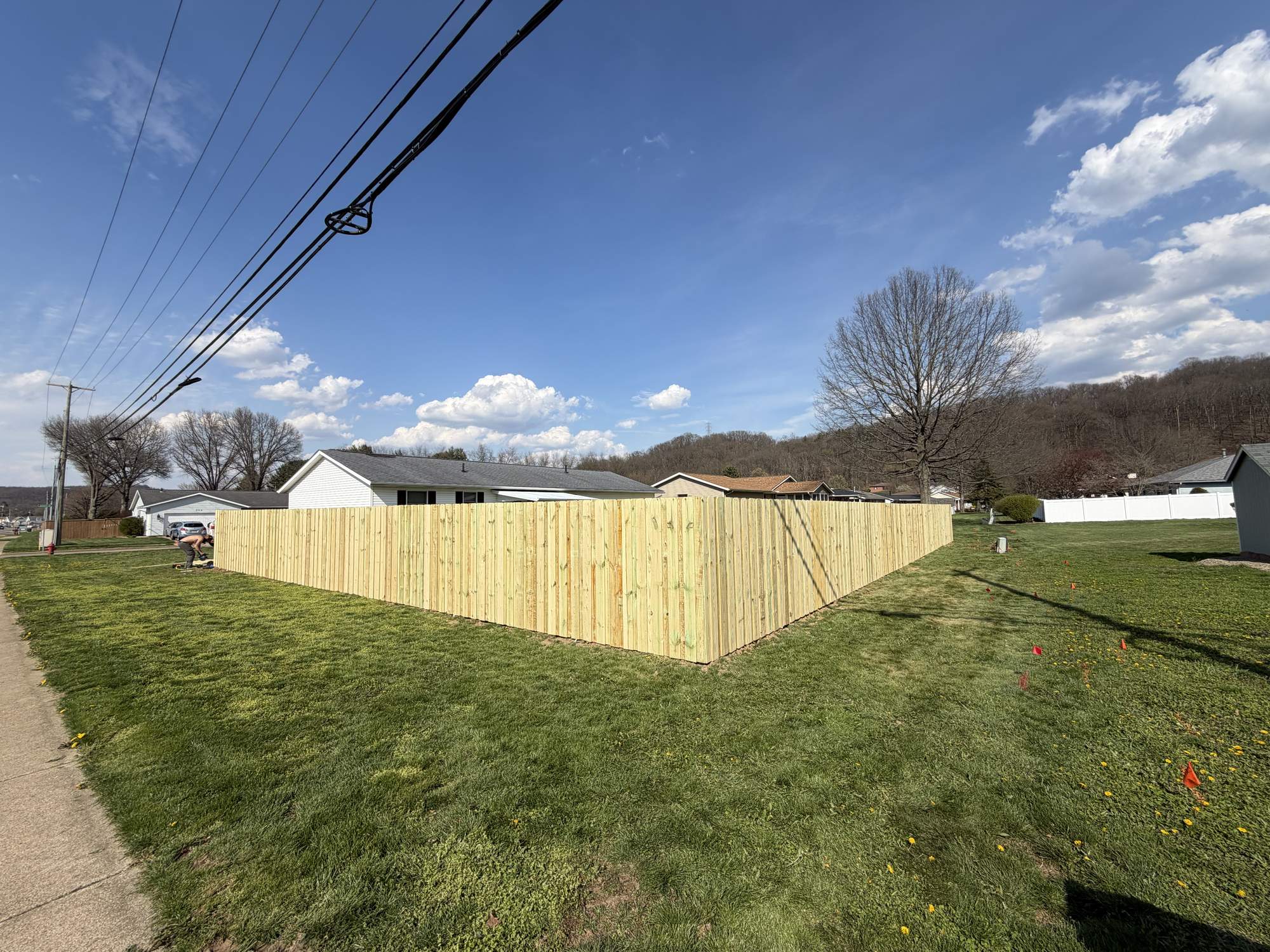 Newly installed wood privacy fence corner on a residential lot in Tuscarawas County, Ohio